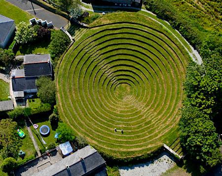 Aerial view of circular grassed pit with descending levels